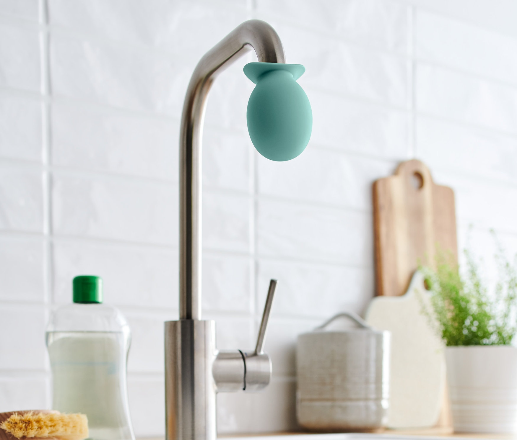 Bir musluğun üzerinde yeşil bir musluk kireç çözücü bulunmaktadır.