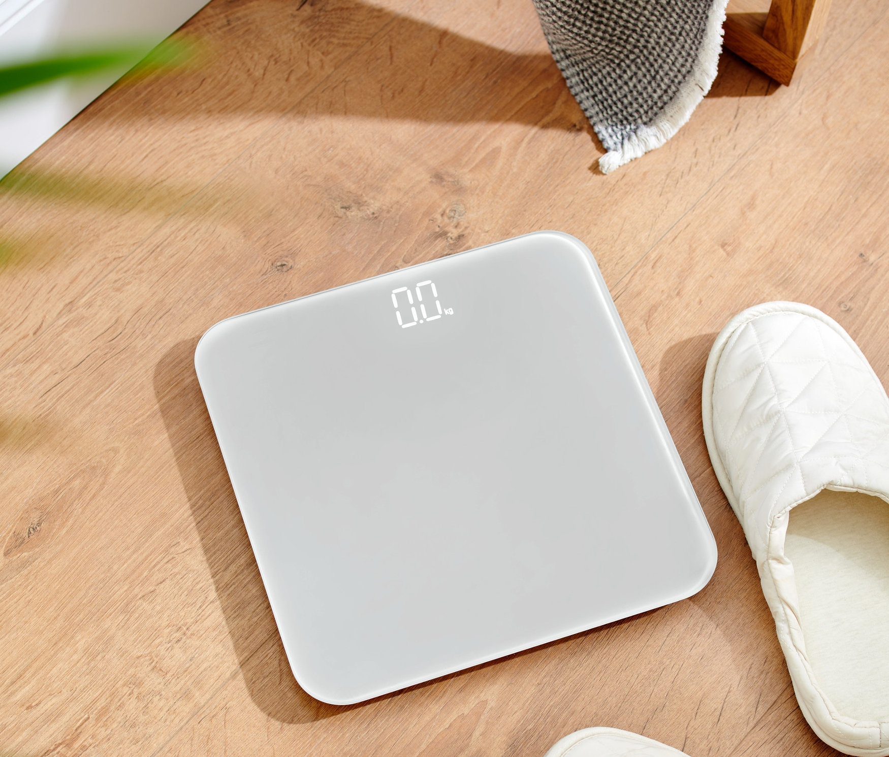 Ahşap zeminde ultra kompakt banyo tartısı duruyor.