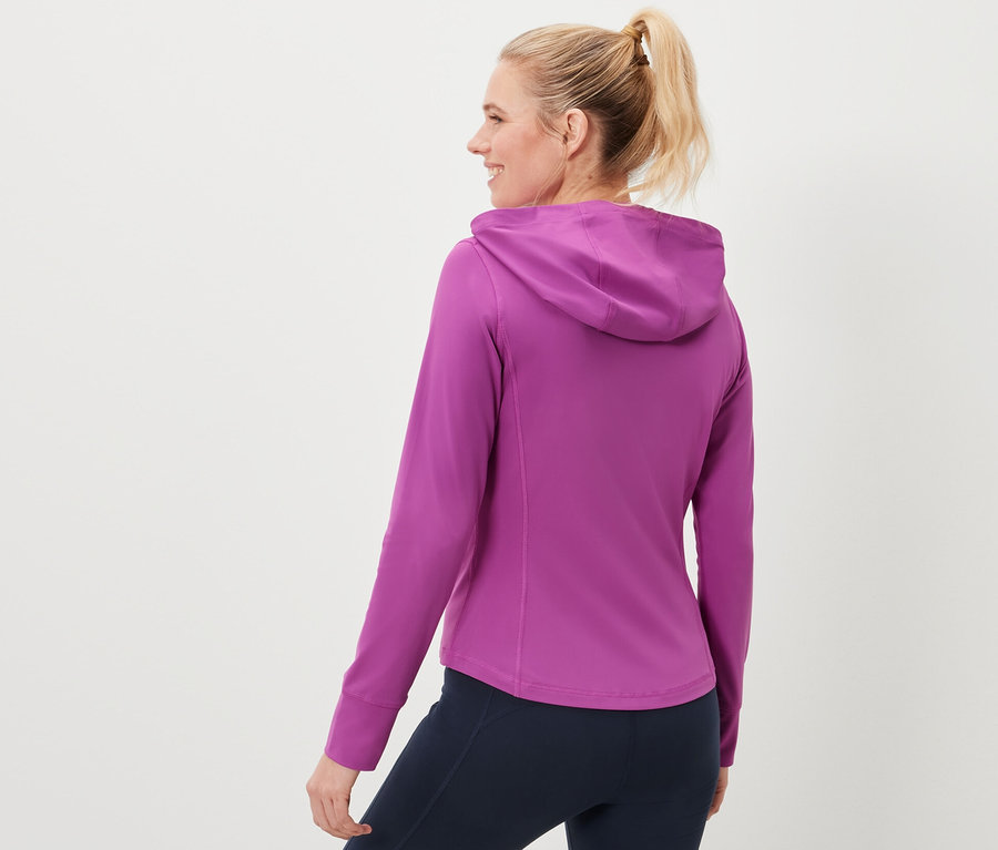 Kadın bir spor ceketi ve lacivert tayt giyiyor.