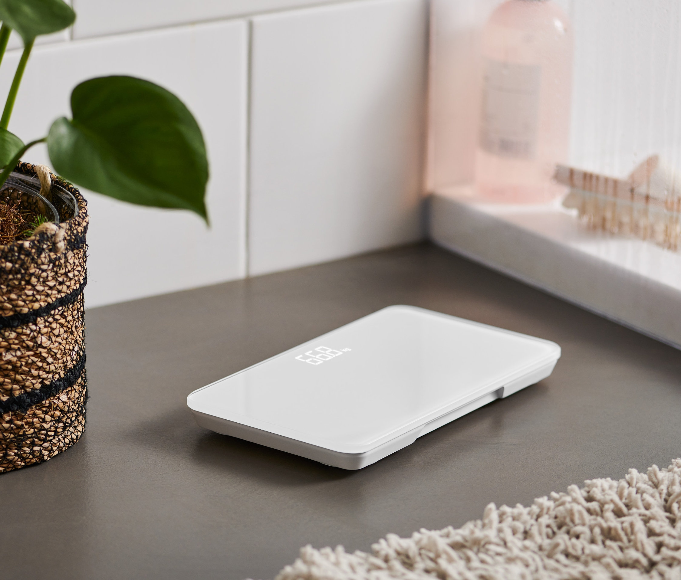 Gri bir zeminde ultra kompakt banyo tartısı duruyor.