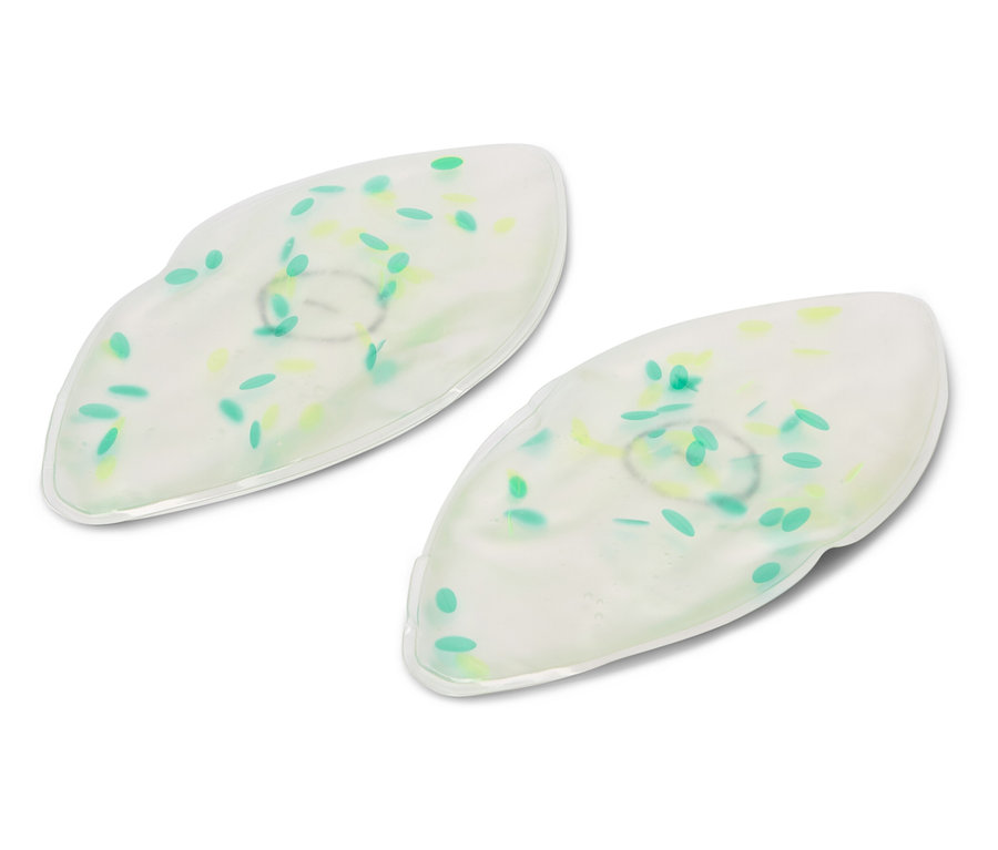 Beyaz zemin üzerinde yeşil ve sarı noktalı iki beyaz jel göz maskesi duruyor.