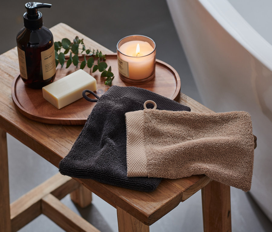 Ahşap bir tabure üzerinde, bir siyah ve bir kahverengi olmak üzere iki adet yüksek kaliteli kese bulunmaktadır. Tabure küvetin yanındadır.