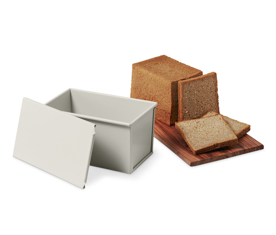 Tam Tahıllı ve Tost Ekmeği Kalıbı ekmek somunu ve dilimlenmiş ekmeğin yanında.