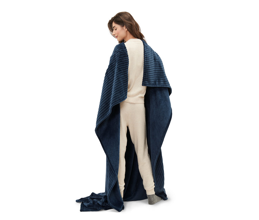 Arkası dönük duran bir kadın, Entegre Kollu Yumuşak Battaniyeye sarılmış.