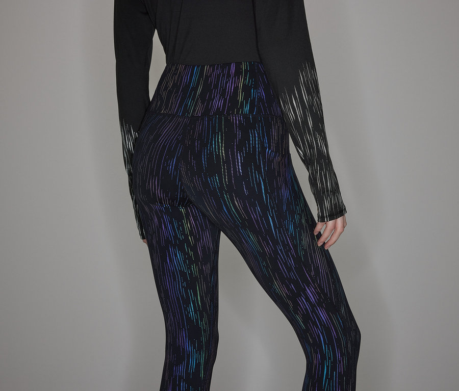 Siyah uzun kollu tişört ve parlak tayt giyen bir kişi.