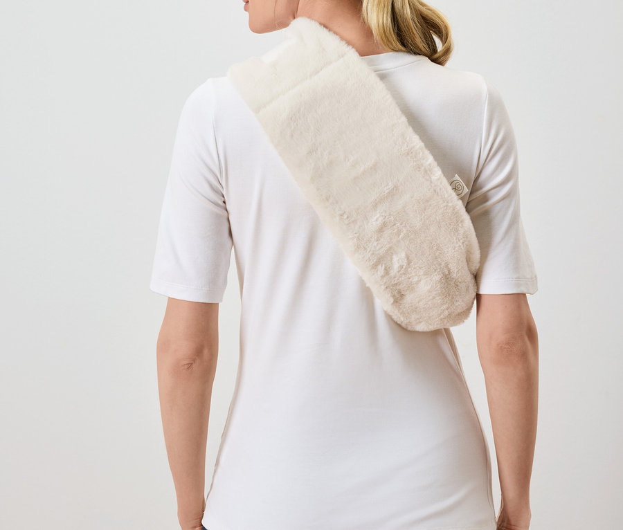 Kadın kameraya arkası dönük, omzuna krem rengi tüylü bir şal atmış.