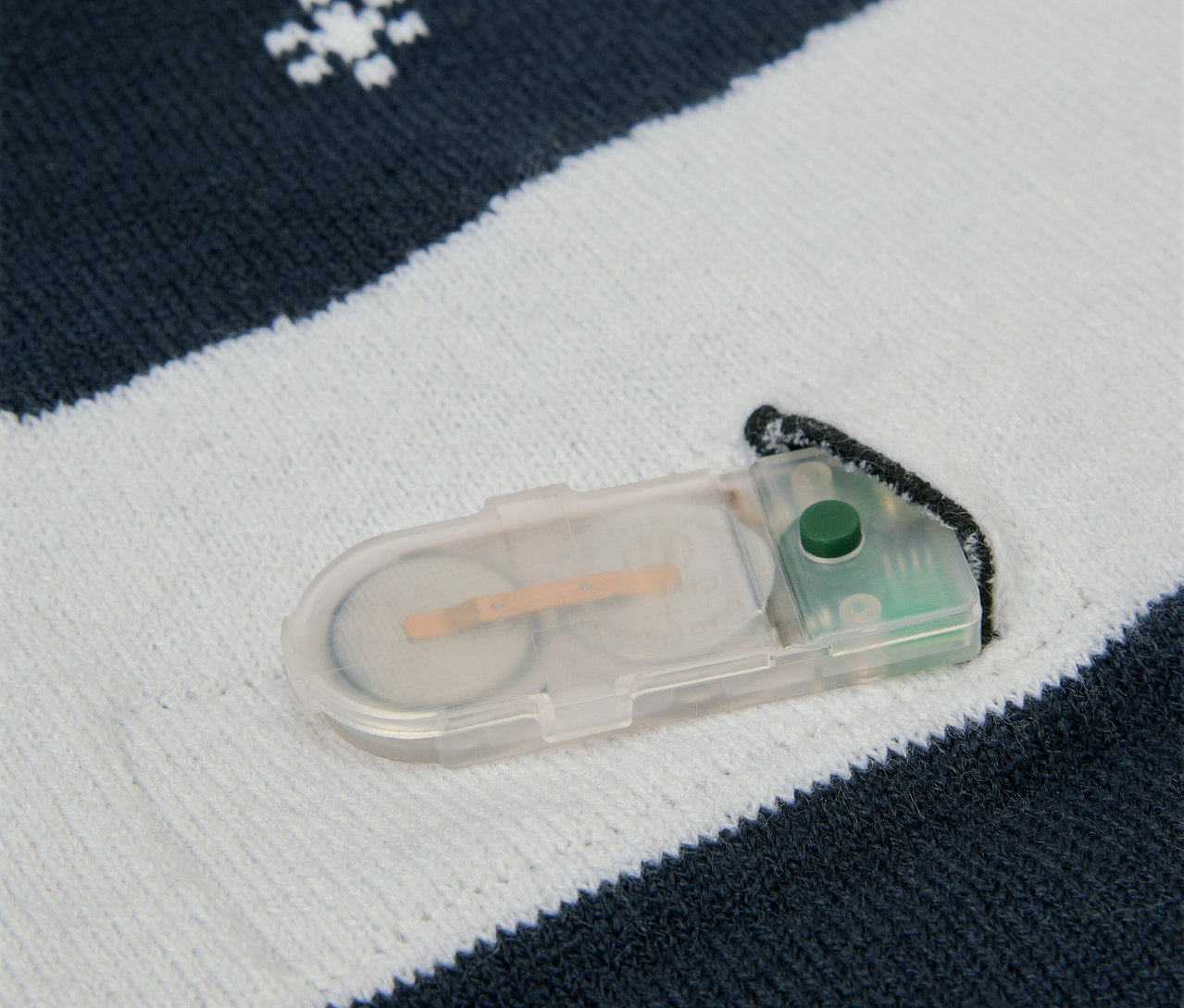 Kar taneleri ve pil bölmesi olan örgü kumaş detayı