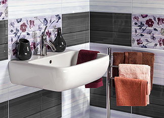 Çiçekli, beyaz ve gri renkli çinileri olan bir lavabo banyoda rahatlatıcı bir atmosfer yaratır.
